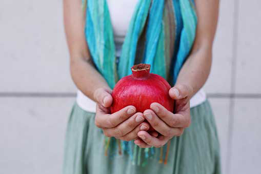 pomegranate in hands of a woman